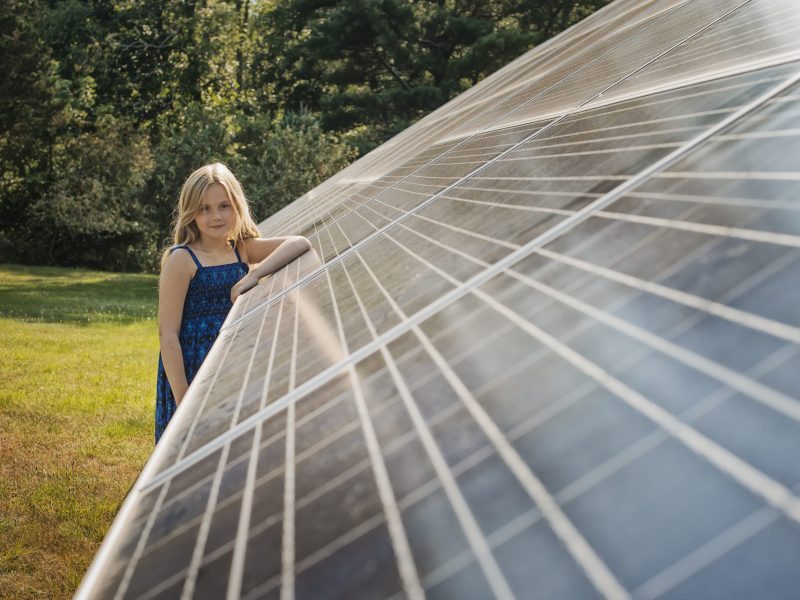 a-young-girl-standing-beside-and-leaning-against-a-ULQCHVR